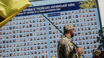 Воїн біля портретів військових