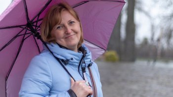 Жінка стоїть під парасолею