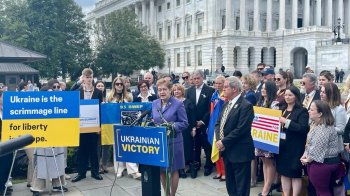 Люди стоять за трибуною