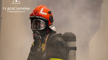 Пожежник стоїть у клубі диму