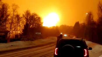 Машина стоїть перед заревом вибуху