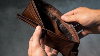 Чоловік тримає пустий гаманець в руках