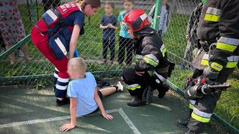 Фото рятувальників, які звільняють дитину з огорожі