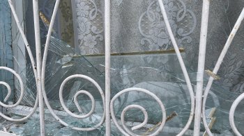 Скло на підвіконні, яке вилетіло внаслідок вибухової хвилі під час обстрілу росіянами Херсона 11 січня 2024, фото «Суспільного»