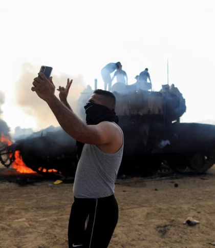 Палестинець на фоні розбитої ізраїльської техніки. Фото: REUTERS/Yasser Qudih