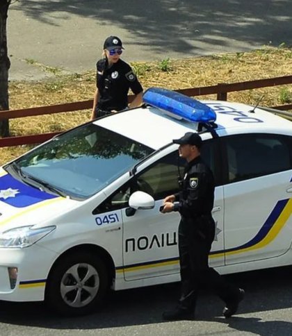 Двоє поліціянтів біля автомобіля, фото ілюстративне