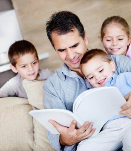 Тато з дітьми читають книжку