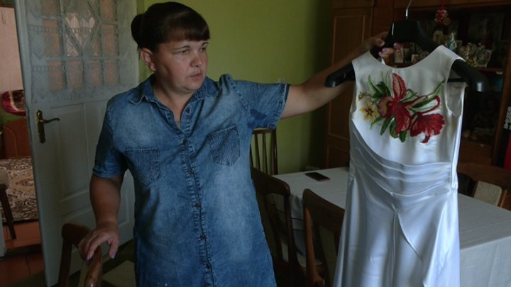 Мирослава Яворська показує сукню, яку оздобила для своєї доньки Катерини. Фото: «Суспільне»