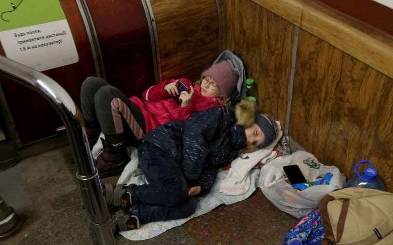 Діти у верхньому одязі сплять на підлозі в укритті. Фото: Уніан